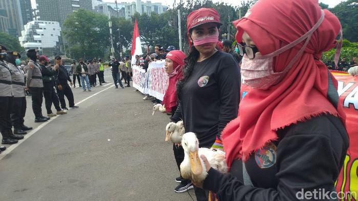 Massa buruh berunjuk rasa membaca bebek