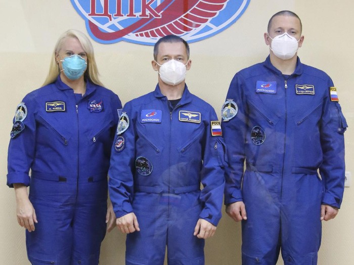 In this handout photo released by Roscosmos, U.S. astronaut Kate Rubins, left, Russian cosmonauts Sergey Ryzhikov, center, and Sergey Kud-Sverchkov, members of the main crew to the International Space Station (ISS), pose for a picture during a news conference at the Baikonur Cosmodrome, Kazakhstan, Tuesday, Oct. 13, 2020. The new Soyuz mission to the International Space Station is scheduled on Wednesday, Oct. 14. (Roscosmos Space Agency Press Service via AP)