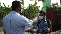 Guru melakukan pengecekan suhu tubuh siswa-siswi Sekolah Menengah Pertama Negeri 1 Gantiwarno, Klaten.