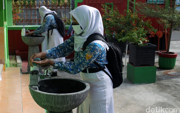 Guru melakukan pengecekan suhu tubuh pada Siswa-siswi Sekolah Menengah Pertama Negeri 1 Gantiwarno, Klaten, saat memasuki area sekolah pada saat uji coba sekolah tatap muka dengan standar protokol kesehatan ketat di Gantiwarno, Klaten, Jawa Tengah.