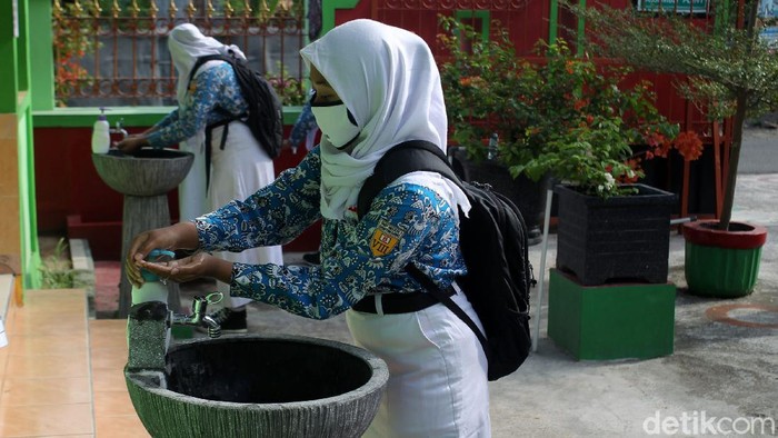 Guru melakukan pengecekan suhu tubuh pada Siswa-siswi Sekolah Menengah Pertama Negeri 1 Gantiwarno, Klaten, saat memasuki area sekolah pada saat uji coba sekolah tatap muka dengan standar protokol kesehatan ketat di Gantiwarno, Klaten, Jawa Tengah.