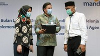 Regional CEO Bank Mandiri Jakarta I Teuku Ali Usman (tengah) menjelaskan kepada nasabah cara bertransaksi secara daring menggunakan aplikasi Mandiri Online disela acara Peresmian Bulan Layanan Digital dan Mandiri Festival Belanja Banten di Bintaro, Tangerang Selatan, Banten. Foto: dok. Mandiri