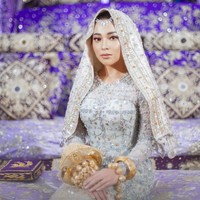 Nikita Willy menggelar Malam Bainai pada Rabu (14/10/2020) setelah pagi harinya melangsungkan pengajian. Ia tampil cantik berbalut busana adat Minang modern bernuansa silver-nude. Foto: Instagram/@thebridestory, @axioo