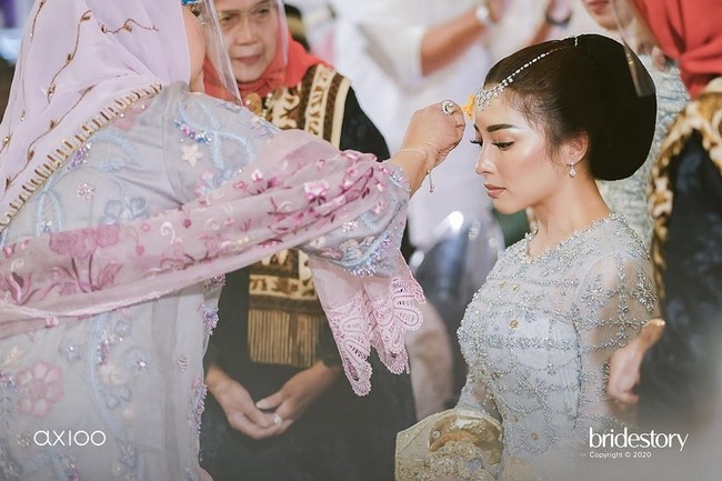 Seperti pengantin Jawa yang menjalani siraman, ritual mandi-mandi juga dilakukan saat Malam Bainai. Tapi Anak Daro tidak dimandikan hingga basah kuyup melainkan hanya dipercikkan air yang sudah diberi haruman kembang tujuh rupa. Pernikahan Nikita Willy sendiri rencananya akan berlangsung pada Jumat (16/10/2020). Foto: Instagram/@thebridestory, @axioo