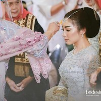 Seperti pengantin Jawa yang menjalani siraman, ritual mandi-mandi juga dilakukan saat Malam Bainai. Tapi Anak Daro tidak dimandikan hingga basah kuyup melainkan hanya dipercikkan air yang sudah diberi haruman kembang tujuh rupa. Pernikahan Nikita Willy sendiri rencananya akan berlangsung pada Jumat (16/10/2020). Foto: Instagram/@thebridestory, @axioo