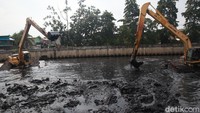 Dua alat berat dikerahkan untuk membantu petugas mengeruk endapan lumpur di kali tersebut.