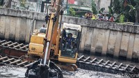 Sejumlah anak tampak menonton proses pengerukan lumpur di Kali Pesing, Jakarta.