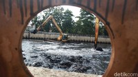 Sejumlah petugas mengerahkan alat berat saat sedang mengeruk lumpur di Kali Pesing, Jakarta, Kamis (15/10/2020).