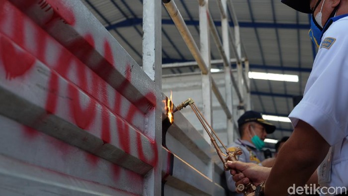 Petugas memotong ukuran truk untuk menormalkan ukurannya.
