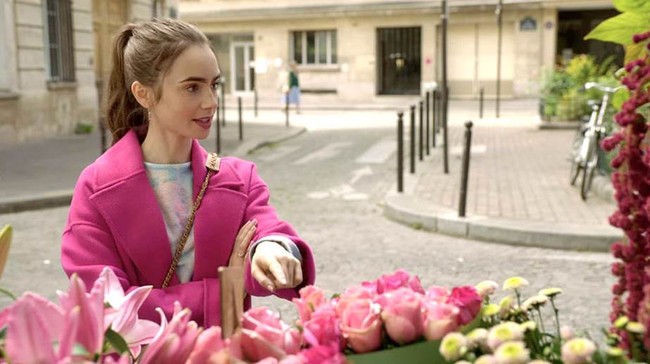 Jangan takut untuk menambahkan warna pada gaya keseharian kamu. Tampilan Emily mengenakan jubah pink Kenzo dan handbag Chanel ini menjadi salah satu gaya ikonik dalam serial 10 episode tersebut. Foto: Netflix/Instagram