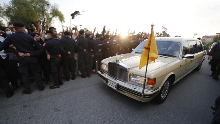 A vehicle with members of the Thai royal family onboard passes through a road where anti-government protesters gathered outside the Government House on Wednesday, Oct. 14, 2020 in Bangkok, Thailand. (AP Photo)