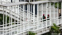 Prajurit Marinir berseragam lengkap itu berpatroli di jembatan penyeberangan orang.