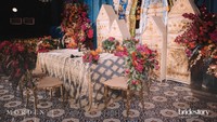 Meja akad nikah dibalut kain bernuansa keemasan. Di sekitarnya terdapat pula dekorasi bunga-bunga yang berwarna merah. Foto: dok Bridestory