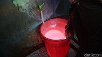 Dengan menggunakan lampu senter, petugas memeriksa bak kamar mandi milik warga.