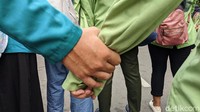 Massa datang dengan long march sambil bergandengan tangan.