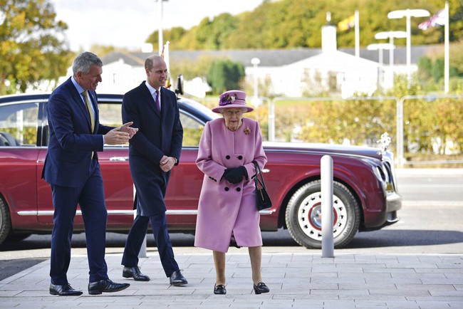 Ratu Elizabeth II melakukan kunjungan resmi ke Defence Science and Technology Laboratory (Dstl) di Porton Down, dekat Salisbury, Inggris, Kamis (15/10/2020). Dikabarkan Daily Mail, ini adalah kali pertama Ratu beraktivitas di luar setelah tujuh bulan karantina di dalam lingkungan istana. Dalam kunjungan tersebut, nenek 94 tahun itu didampingi cucunya, Pangeran William. (Foto: AP/Ben Stansall)