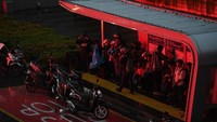 Sejumlah warga berteduh di sebuah halte saat turun hujan di Jalan Jenderal Sudirman, Jakarta.