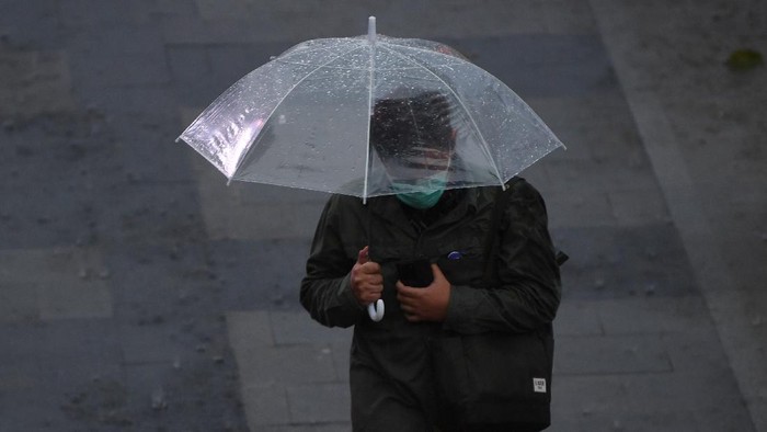 Seorang warga mengenakan jas hujan saat melintas di jembatan penyeberangan orang (JPO) di Senayan, Jakarta, Jumat (16/10/2020). Menurut Badan Meteorologi, Klimatologi dan Geofisika (BMKG) musim hujan di Indonesia telah berlangsung dari bulan Oktober dan diprediksi puncak musim hujan terjadi pada Januari hingga Februari 2021. ANTARA FOTO/Wahyu Putro A/wsj.