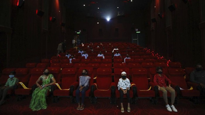 People watch an Indian Bollywood movie as cinemas reopen with a special screening for COVID- 19 warriors and their families at the PVR movie theater in New Delhi, India, Thursday, Oct. 15, 2020. Seven months after screens went dark, cinemas reopened Thursday in much of India with mostly old titles on the marquee — a sign of the country's efforts to return to normal as the pace of coronavirus infections slows but also of the roadblocks that remain. (AP Photo/Manish Swarup)