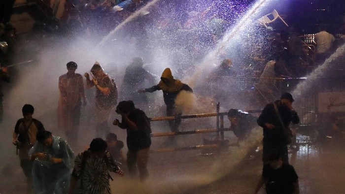 Police use water canons to try and disperse demonstrators from their protest venue in Bangkok, Thailand, Friday, Oct. 16, 2020. Thailand prime minister has rejected calls for his resignation as his government steps up efforts to stop student-led protesters from rallying in the capital for a second day in defiance of a strict state of emergency. (AP Photo/Sakchai Lalit)