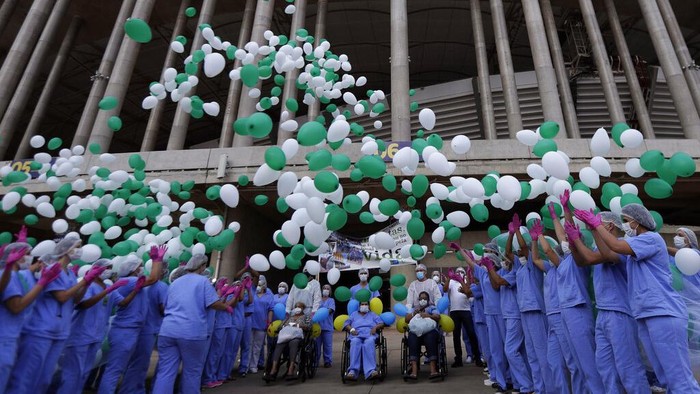 Potret Haru Nakes Antar Pulang Pasien COVID-19 Terakhir RSD Brasil Medical workers embrace while they celebrate as the last three patients are released from a field hospital at the National Stadium Mane Garrincha, after recuperating from COVID-19, in Brasilia, Brazil, Thursday, Oct. 15, 2020. (AP Photo/Eraldo Peres)