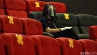Seorang warga tengah menonton di bioskop.