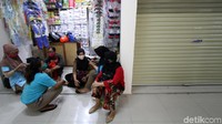 Beberapa pedagang menunggu pembeli sambil berbincang di depan kios.