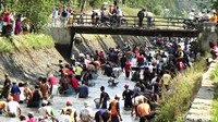 Selain membersihkan sampah di sungai untuk mencegah banjir, warga juga melakukan panen ikan dengan menangkapnya beramai-ramai.
