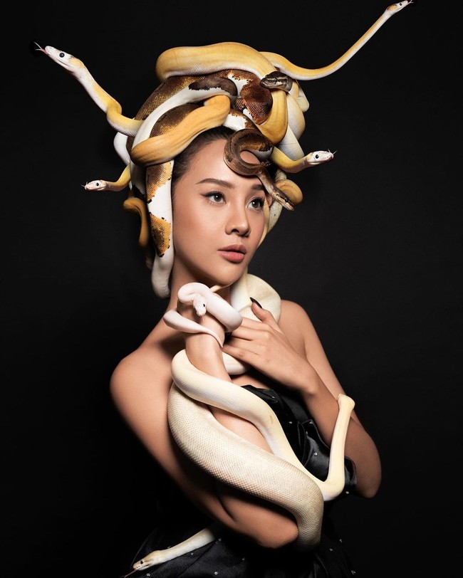 Di foto ini, di kepalanya paling tidak ada enam ular yang menjadi mahkota Anya. Sementara dua ular lain yang lebih besar didekapnya dengan tangan. Foto: Instagram @11.11studiojakarta