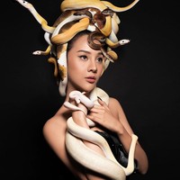 Di foto ini, di kepalanya paling tidak ada enam ular yang menjadi mahkota Anya. Sementara dua ular lain yang lebih besar didekapnya dengan tangan. Foto: Instagram @11.11studiojakarta