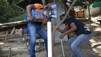 Para relawan kucing itu membangun tempat makan dan minum kucing seperti dispenser yang terbuat dari pipa PVC.  