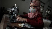 Pekerja menyelesaikan pembuatan masker kain di industri rumahan Batik Seno, Yogyakarta, Senin (19/10/2020).   