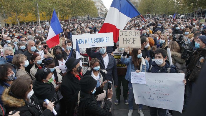 Ribuan Orang Kumpul di Paris Protes Pemenggalan Guru People gather on Republique square during a demonstration Sunday Oct. 18, 2020 in Paris. Demonstrations around France have been called in support of freedom of speech and to pay tribute to a French history teacher who was beheaded near Paris after discussing caricatures of Islam's Prophet Muhammad with his class. Samuel Paty was beheaded on Friday by a 18-year-old Moscow-born Chechen refugee who was shot dead by police. (AP Photo/Michel Euler)
