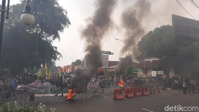 Sejumlah mahasiswa melakukan aksi memperingati satu tahun pemerintahan Jokowi-Maruf Amin di sekitar istana bogor. Mereka membakar ban dan membawa keranda menuju Istana Bogor.