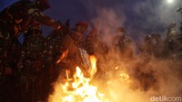 Dengan peralatan seadanya, para prajurit ini terus memadamkan ban yang dibakar massa.