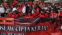 Unjuk rasa dilakukan dengan membentangkan spanduk raksasa.