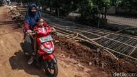 Pengendara motor melintas di samping proyek penurapan anak sungai di Ciputat Timur, Tangerang Selatan, Selasa (20/10/2020).  