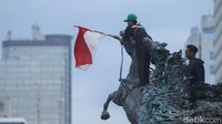 Tak hanya itu beberapa massa aksi juga menunggangi patung kuda dan memasang bendera merah putih.
