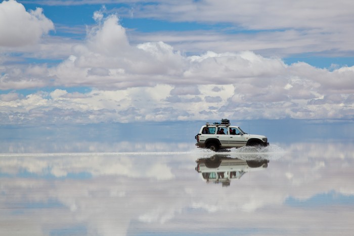 BOLIVIAN ALTIPLANO, BOLIVIA - March 02, 2011: 4x4 crossing the Salar de Uyuni, Bolivia. people doing a trek in high altitude in a Toyota Land Cruser 1999.  Toyota is a multinational automaker headquartered in Toyota, Aichi, Japan.