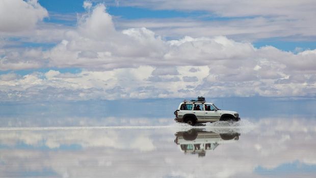 BOLIVIAN ALTIPLANO, BOLIVIA - March 02, 2011: 4x4 crossing the Salar de Uyuni, Bolivia. people doing a trek in high altitude in a Toyota Land Cruser 1999.  Toyota is a multinational automaker headquartered in Toyota, Aichi, Japan.