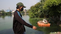Seorang warga melintas di tepi Rawa Badung. Petugas Unit Pelaksana Kebersihan Badan Air Dinas Lingkungan Hidup DKI Jakarta membersihkan sampah Situ Rawa Badung di Cakung, Jakarta Timur.