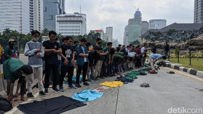 Tolak Omnibus Law, Massa Aksi Sholat Dhuzur Bersama di Depan Patung Kuda Para mahasiswa massa aksi mulai berdatangan di kawasan Patung Kuda, Jakarta Pusat. Sebelum melakukan aksi demo, para massa aksi menunaikan ibadah sholat Dhuzur berjamaah.