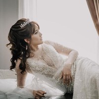 Untuk momen spesial tersebut, perempuan 33 tahun ini menebar pesonanya dalam balutan gaun putih berhiaskan embellishment yang berkilauan. Neckline gaun yang rendah sukses mengakomodasi keseksian Angela. (Foto: Instagram/@memoirastudio)