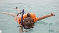 Mengancungkan jempol, Gempi sepertinya menikmati keseruan snorklingnya.
