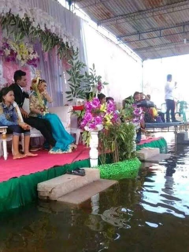 Banjir pun tetap diterjang asalkan acara pernikahan tetap bisa berlangsung. Jadi kelihatan kayak nikah di tengah kolam ya? Foto: Twitter/ibrhmihsan