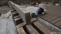 Seorang pekerja sedang mencetak batu bata untuk kemudian dikeringkan.