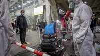 Para petugas bandara terlihat sibuk menyemprotkan disinfektan ke semua barang yang dibawa oleh turis. (AP/Wason Wanichakorn)