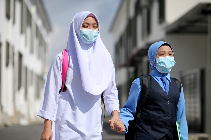 Two Muslim teenage sisters feeling excited to back to school after lockdown order is lifted in Malaysia.