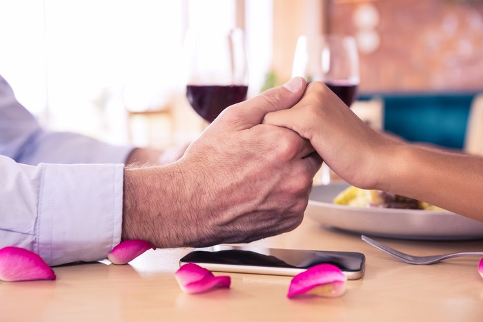 Man holding hands of woman in restaurant