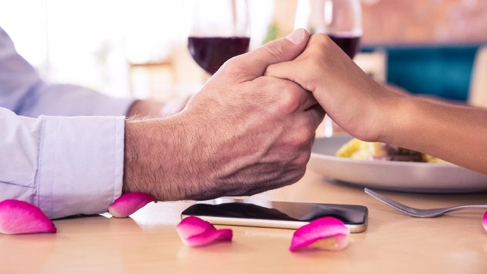 Man holding hands of woman in restaurant